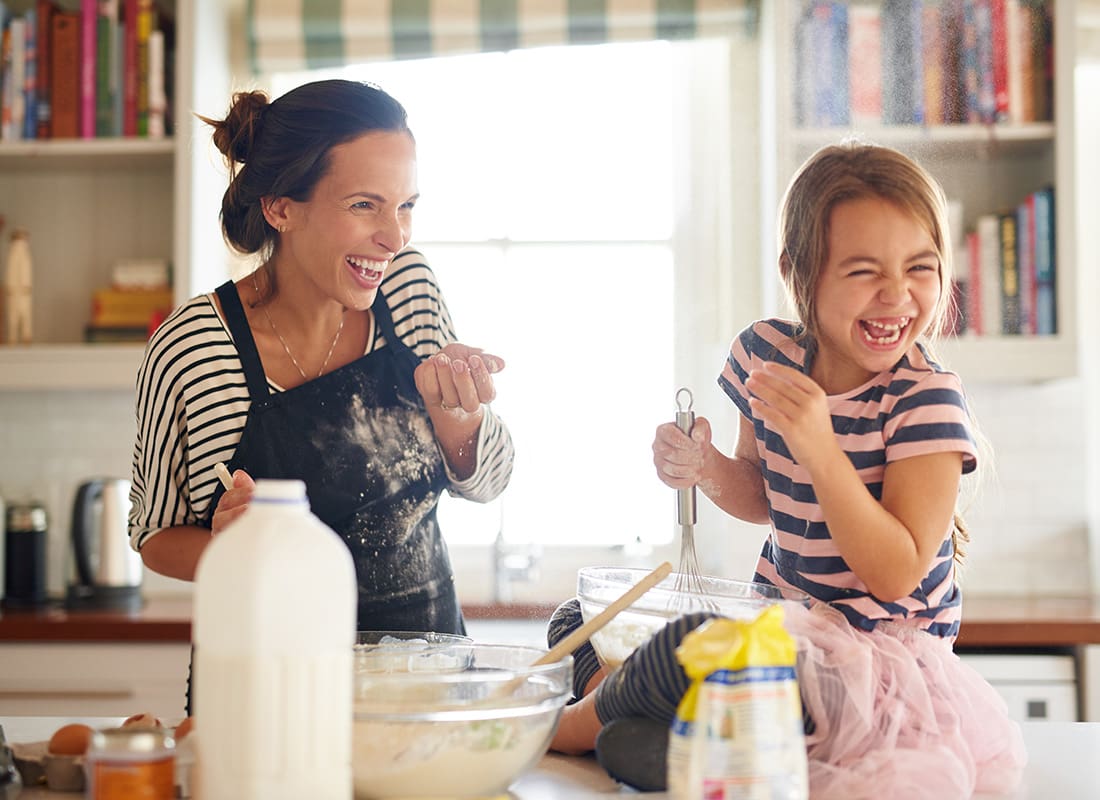 Personal Insurance - Cheerful Mom and Young Daughter Having Fun Baking Together in the Kitchen